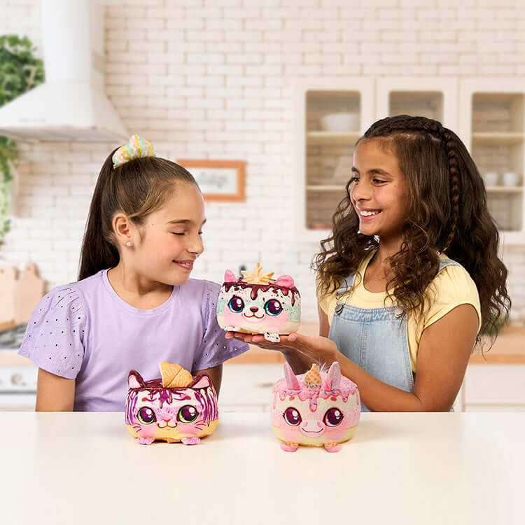 Two girls joyfully playing with Cookeez Makery S2 Freezy Cakez Playset, showcasing colorful plush treats.