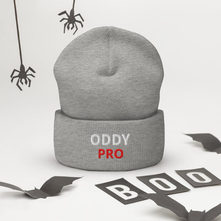 Oddy Pro Cuffed Beanie displayed in grey with spooky decorations for Halloween.